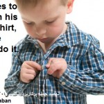 Child learning to button his own shirt.